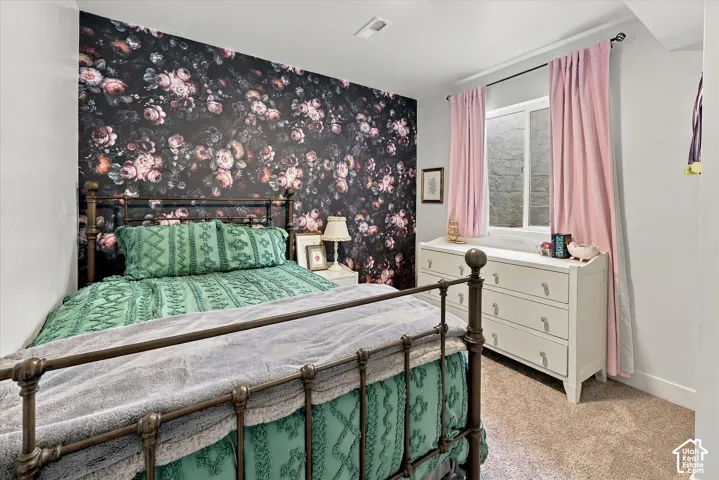 Feature wall with floral pattern, carpeted flooring, and a window opening