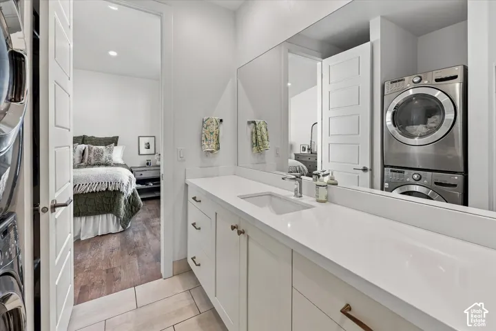 Expansive vanity with a single basin, white countertop, and integrated stackable laundry appliances