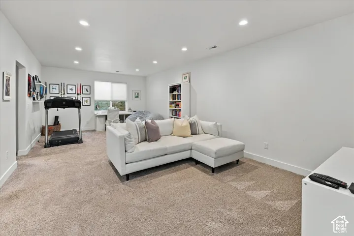 Recessed lighting, light-toned carpeting, white walls, and a built-in shelving unit