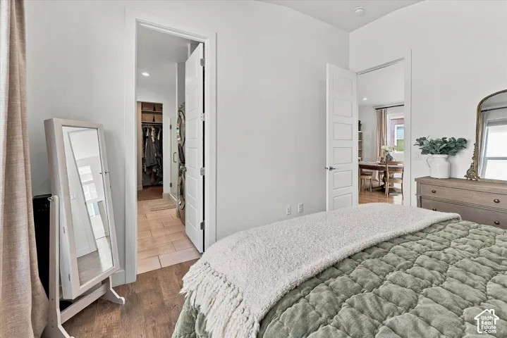 Wood-finish flooring with white walls and a white door featuring five recessed panels