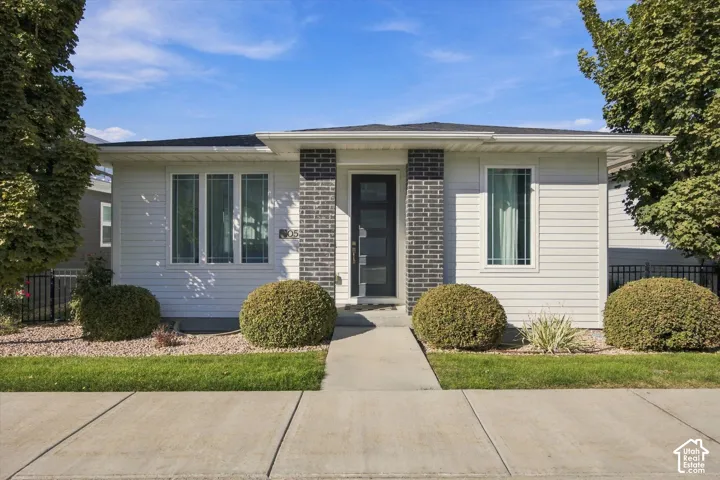 Contemporary exterior with white horizontal siding and dark brick accents