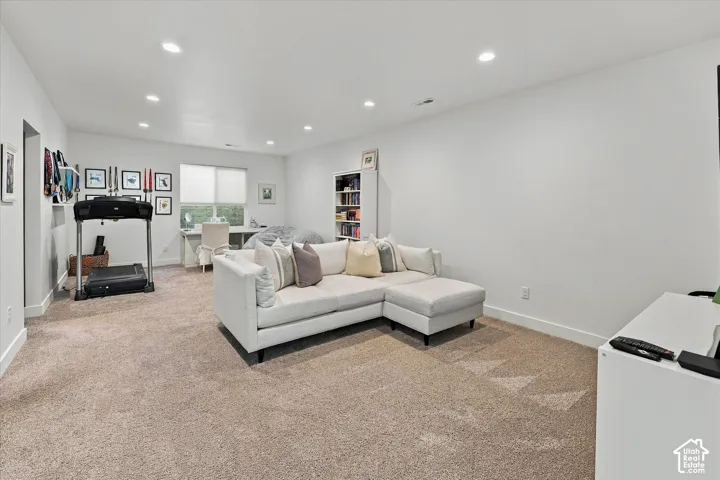 Recessed lighting, light-toned carpeting, and white wall finishes