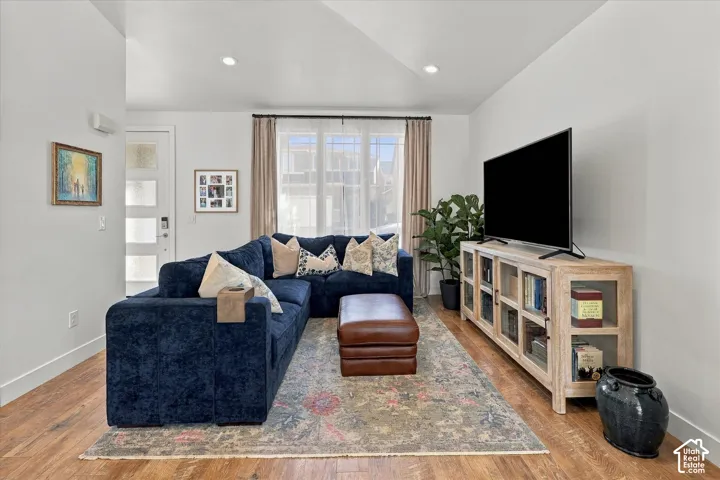 Recessed lighting illuminates this bright interior space with wood-finish flooring