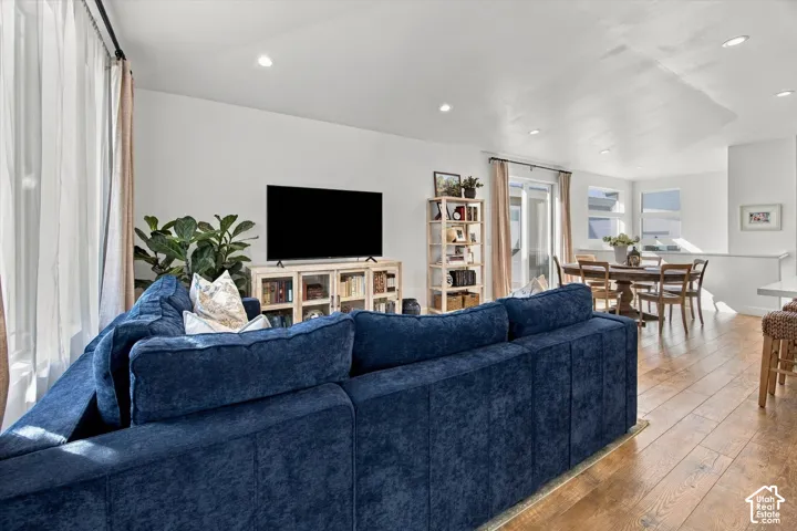 Open-concept living area featuring wood-finish flooring, recessed lighting, and white walls