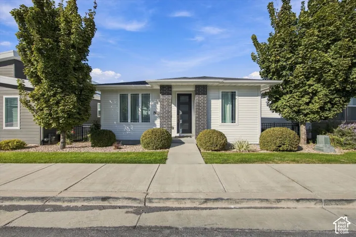 Contemporary exterior featuring white horizontal siding, a dark entry door, and a concrete walk
