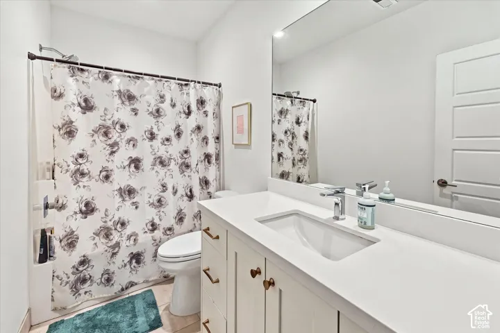 White vanity with rectangular undermount sink, chrome faucet, and bronze cabinet pulls