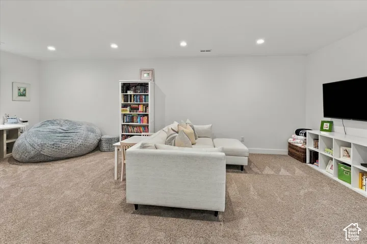 Recessed ceiling lighting, neutral carpeting, and built-in shelving units