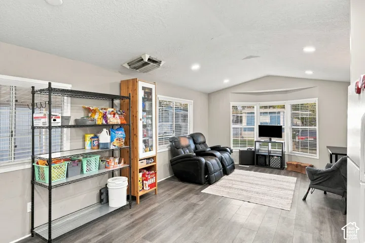 Wood-finish flooring, recessed ceiling lighting, and a bay window