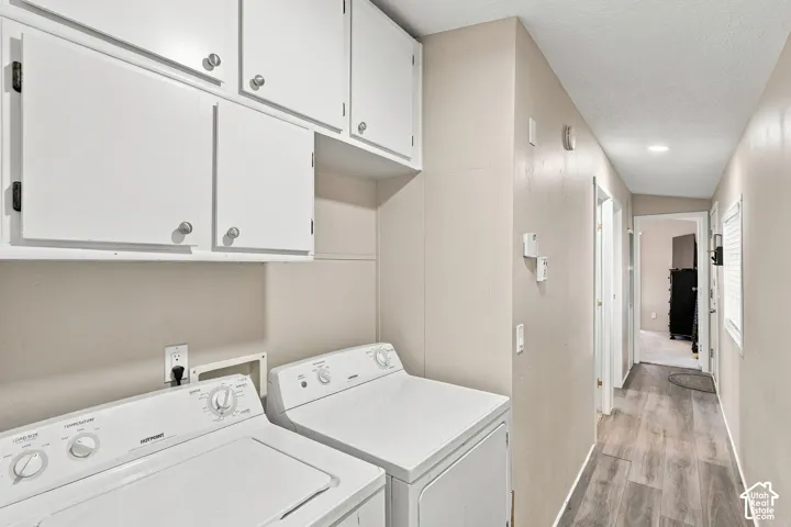 White upper cabinetry with brushed nickel hardware and a dedicated laundry area