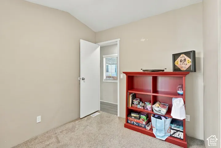 Carpeted room with neutral wall tones and a white door
