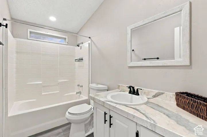 White vanity with a stone-look countertop, undermount sink, and black fixtures