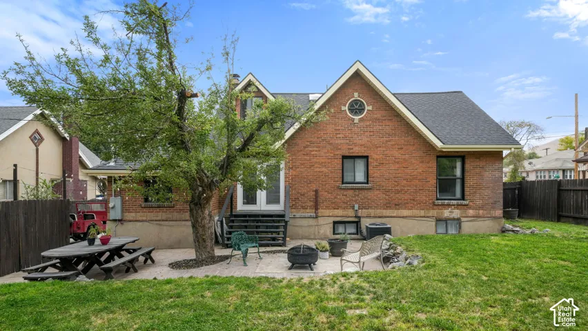 Brick exterior with white trim, a circular attic window, and a dark shingle roof