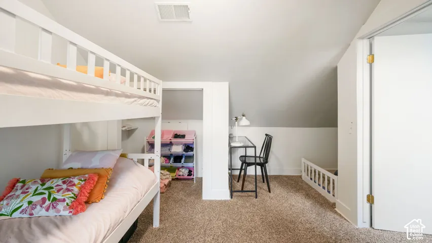 Sloped ceiling, carpet flooring, bunk bed, white trim, recessed alcove