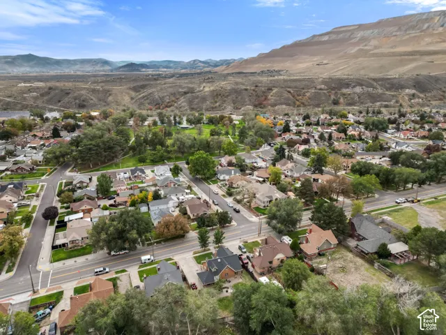 Residential neighborhood with mature trees and paved streets, framed by a prominent mountain and distant foothills