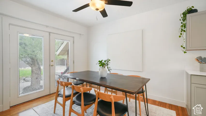 Wood-finish flooring, white walls, and a ceiling fan with integrated lighting