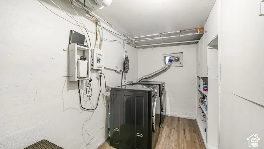 Utility area with wood-finish flooring, built-in cabinetry, and a window