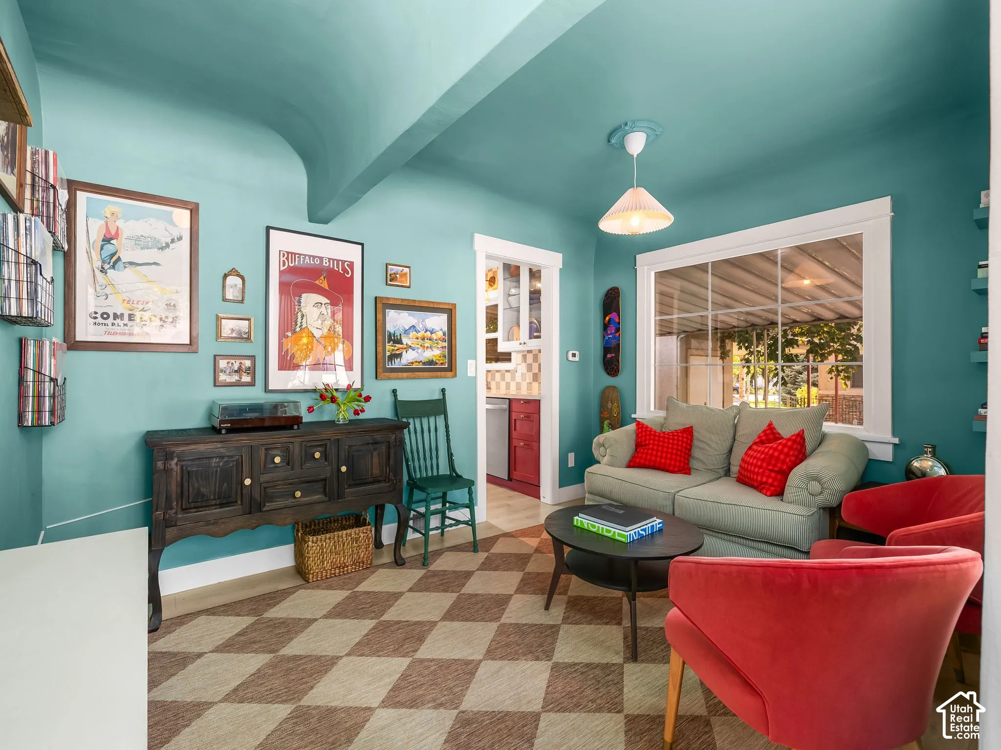 Turquoise walls and vaulted ceiling create an inviting living space anchored by a geometric wood-finish floor