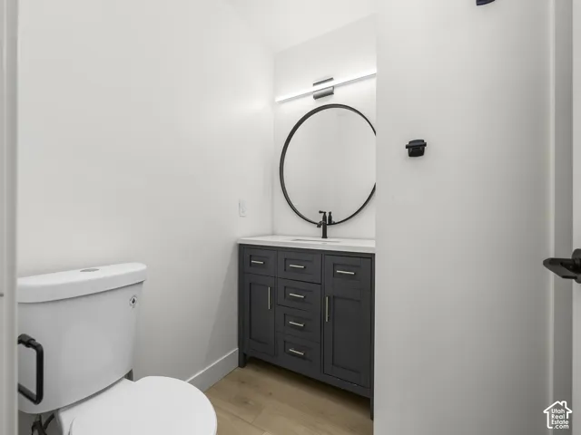 Modern vanity with a dark gray finish, a white countertop, and a circular mirror