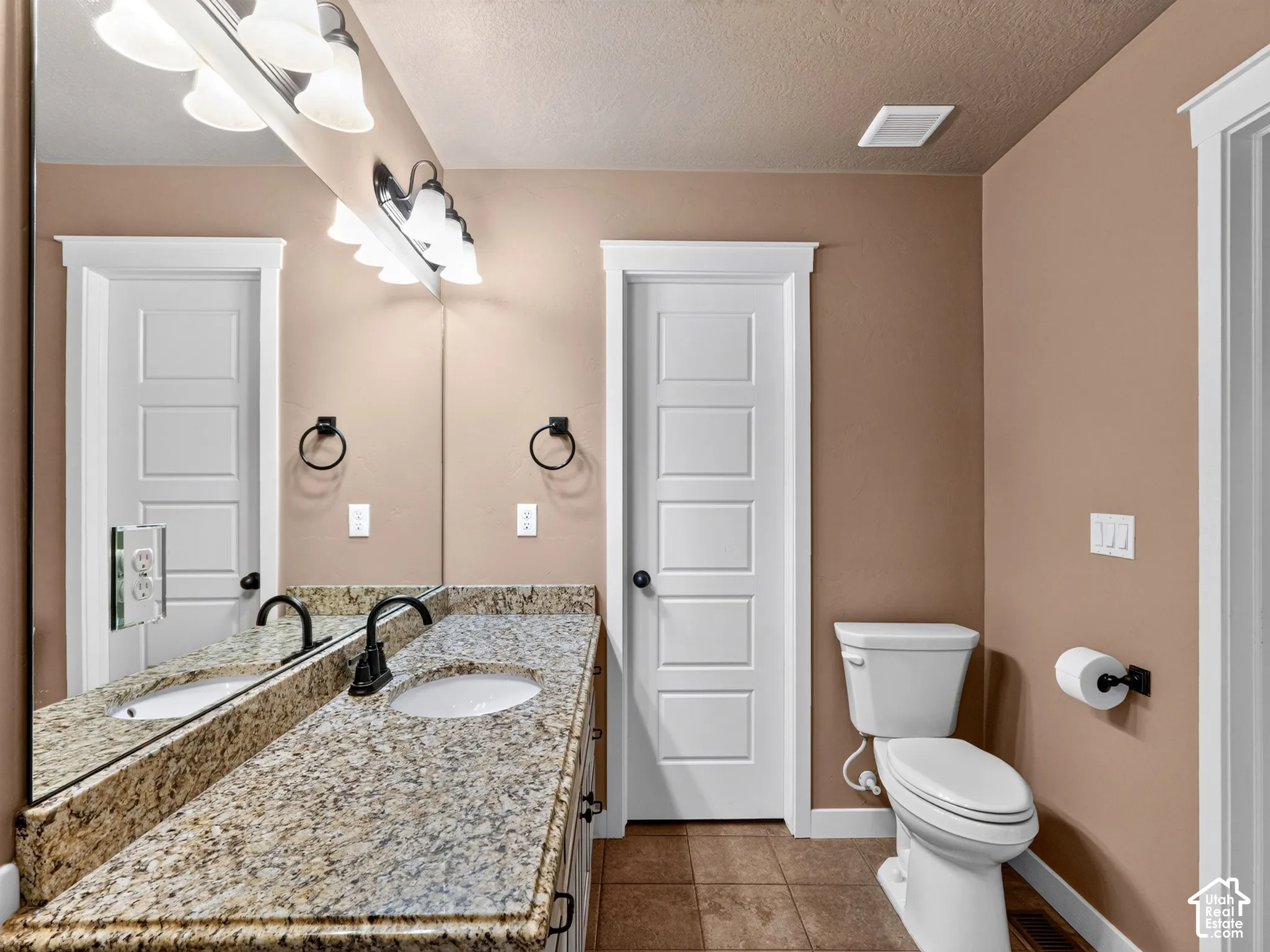 Dual vanity with granite countertops, undermount sinks, and matte black fixtures