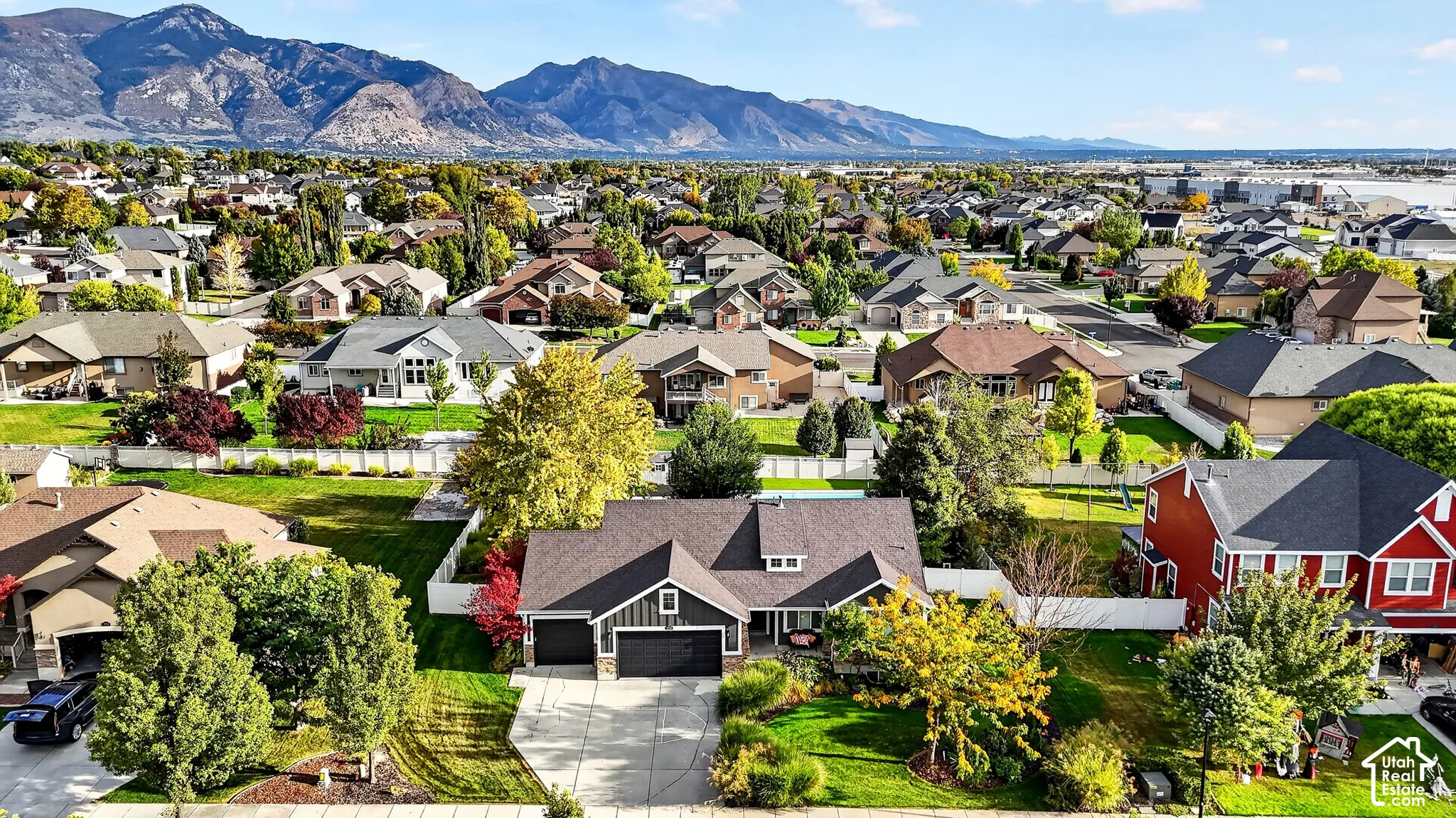 Mountain range backdrop, residential neighborhood, varied architectural styles, mature trees, manicured lawns
