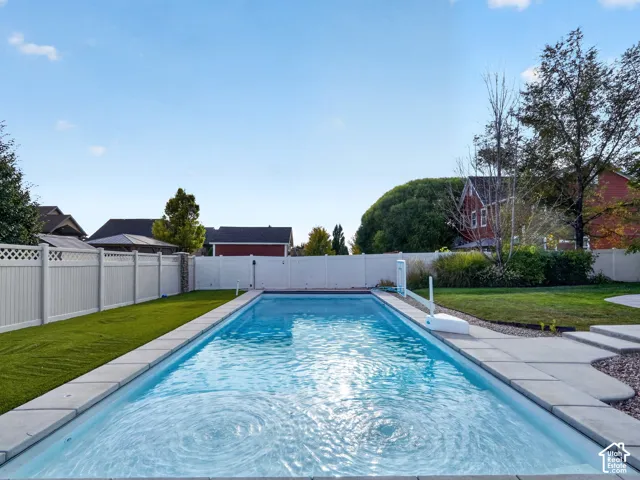 Rectangular in-ground swimming pool with surrounding concrete coping