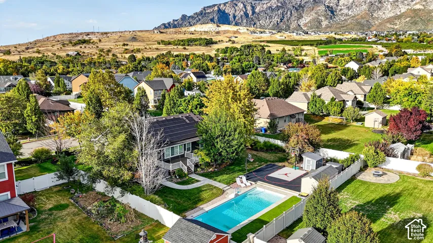 Property featuring a swimming pool, paved sports court, storage sheds, and a fire pit area