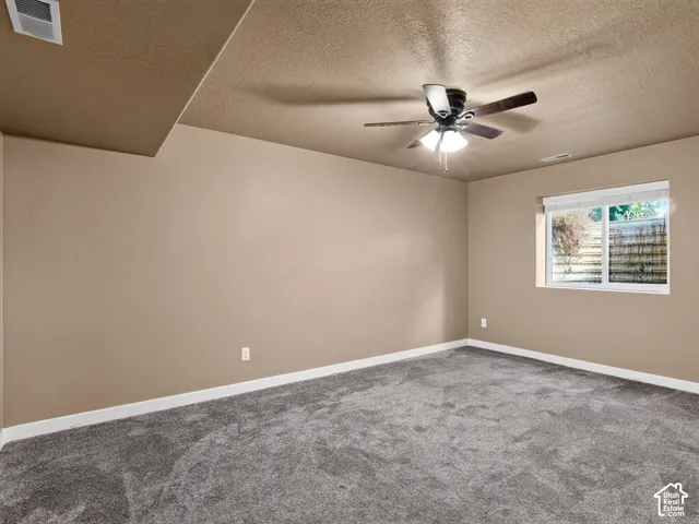 Neutral-toned walls complement plush grey carpeting