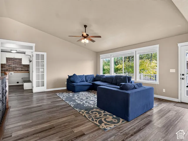Vaulted ceilings, wood-finish flooring, ceiling fan, white trim windows, and a built-in storage bench