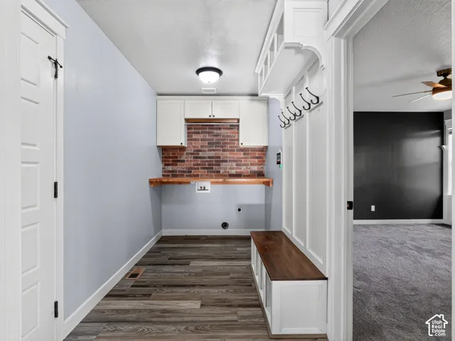 Wood-finish flooring, built-in storage bench, and a brick-finish backsplash