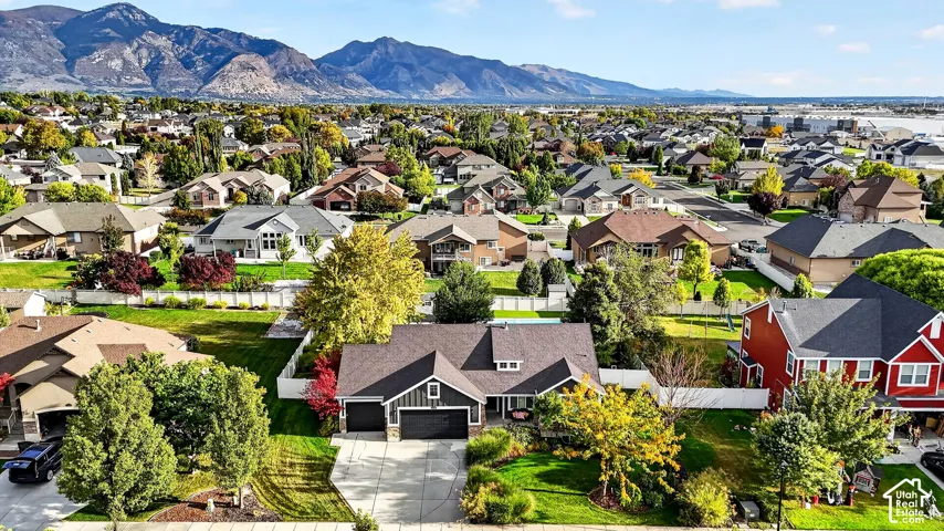 Mountain range backdrop, residential neighborhood, varied architectural styles, mature trees, manicured lawns