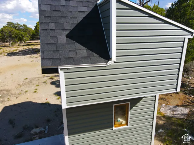 Asphalt shingle roofing, horizontal siding, white trim, and a rectangular window
