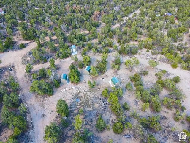 Expansive natural landscape featuring dense tree coverage and multiple shed structures