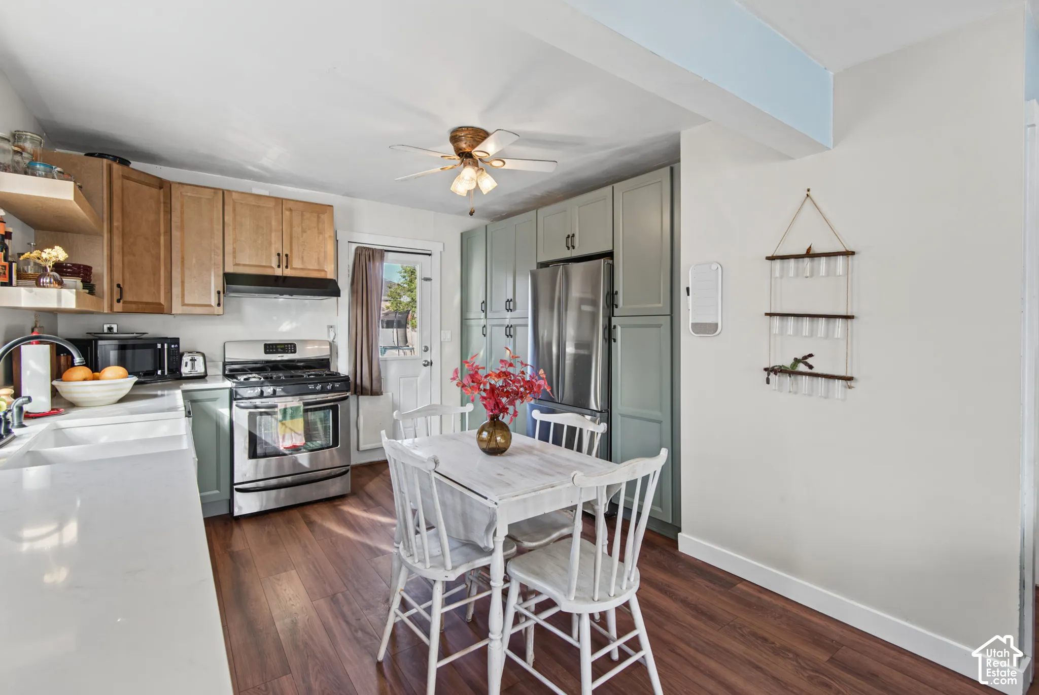 Kitchen featuring wood-finish flooring, white countertops, stainless steel appliances, and mixed-tone cabinetry