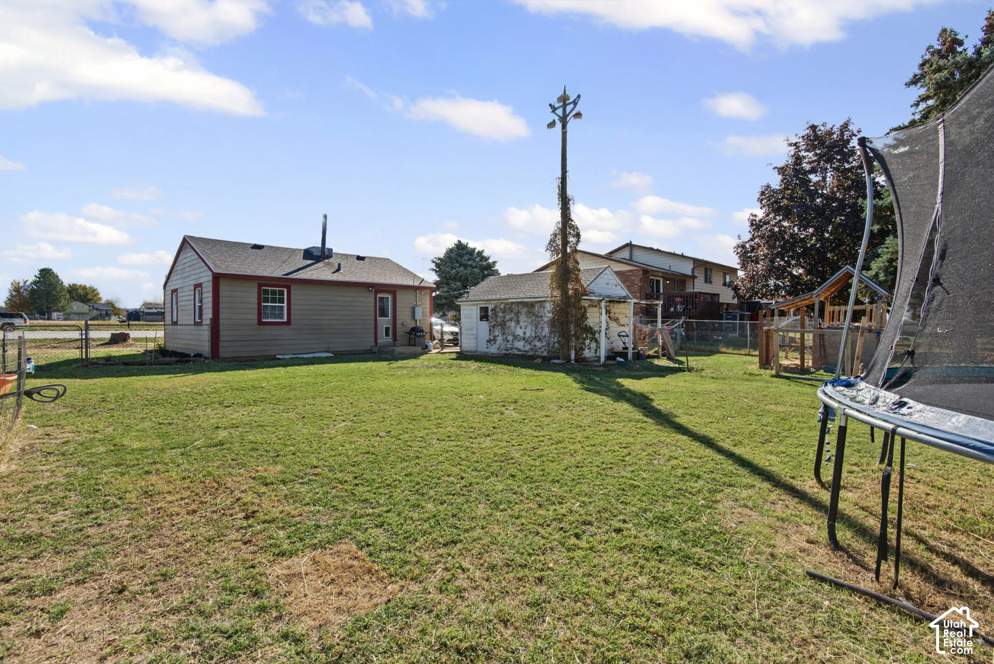 Expansive grassy yard with a detached structure and a play set