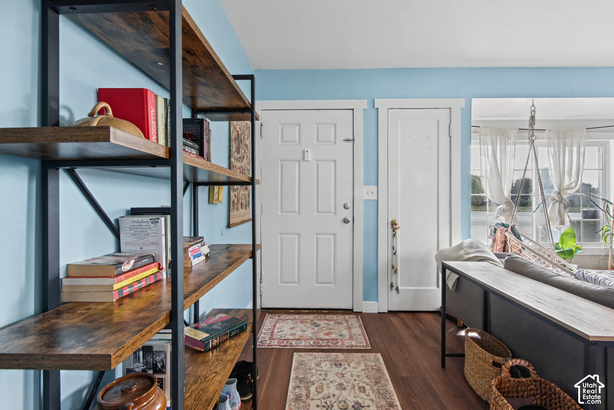 Wood-finish flooring, built-in shelving, white trim, and a window with natural light