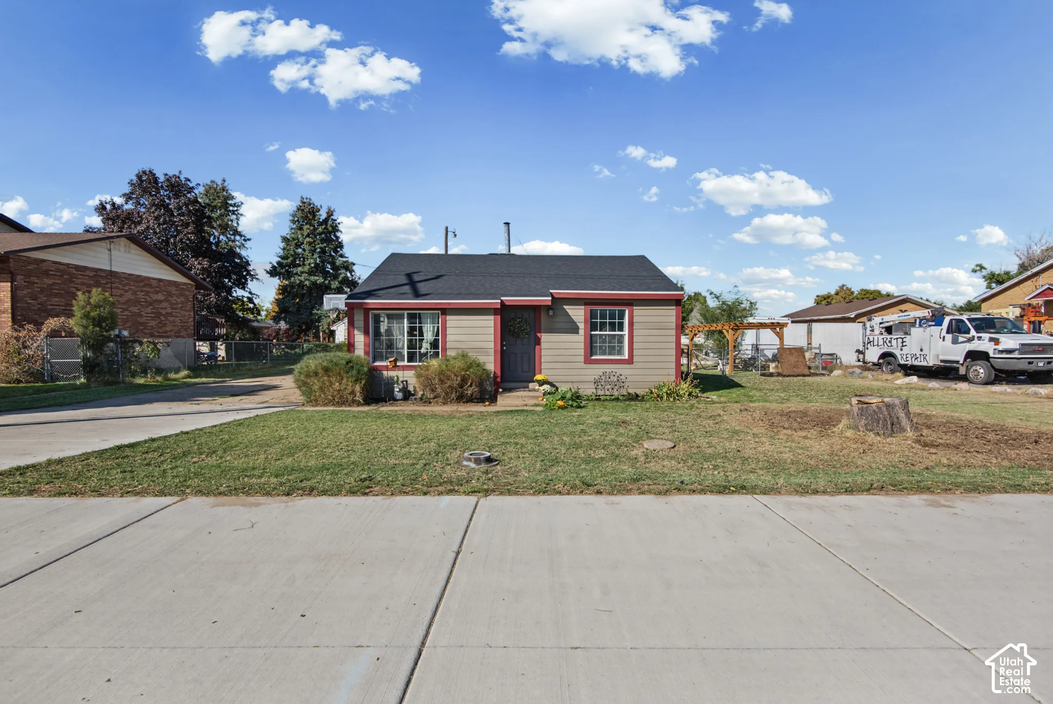 Single-story residence featuring light-colored siding with red trim accents