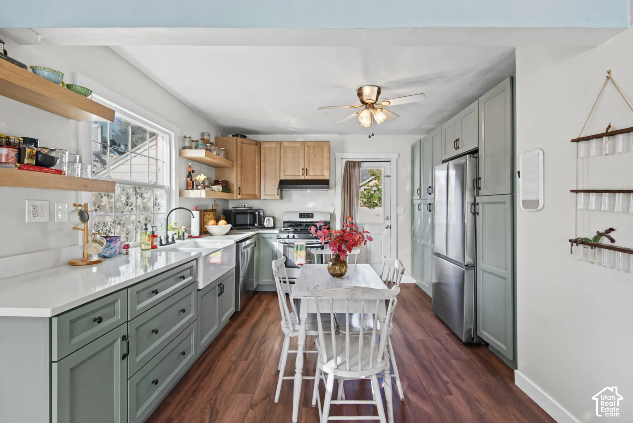 Kitchen featuring wood-finish flooring, white countertops, a farmhouse sink, and a combination of natural wood and sage-colored cabinetry