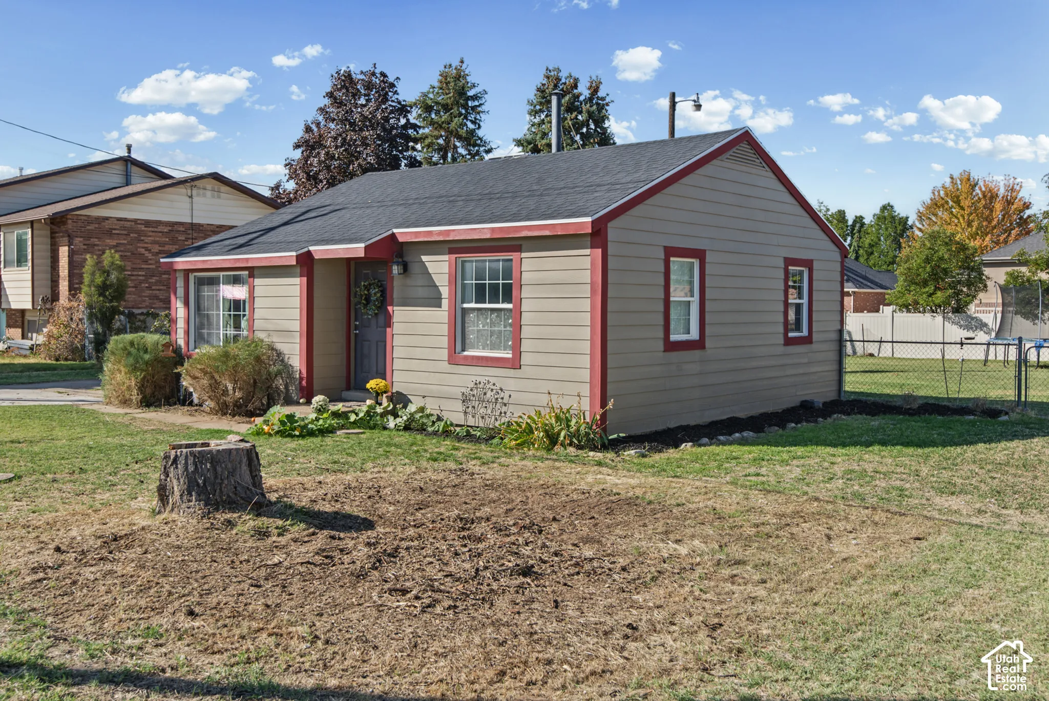 Single-story residence with siding exterior, contrasting trim, and a fenced yard