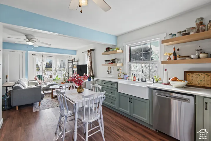 Wood-finish flooring throughout, featuring a kitchen with light green cabinetry, a farmhouse sink, and stainless steel appliances