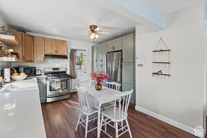 Kitchen featuring wood-finish flooring, white countertops, stainless steel appliances, and mixed-tone cabinetry