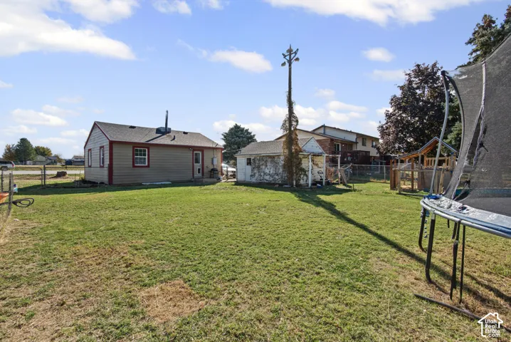 Expansive grassy yard with a detached structure and a play set