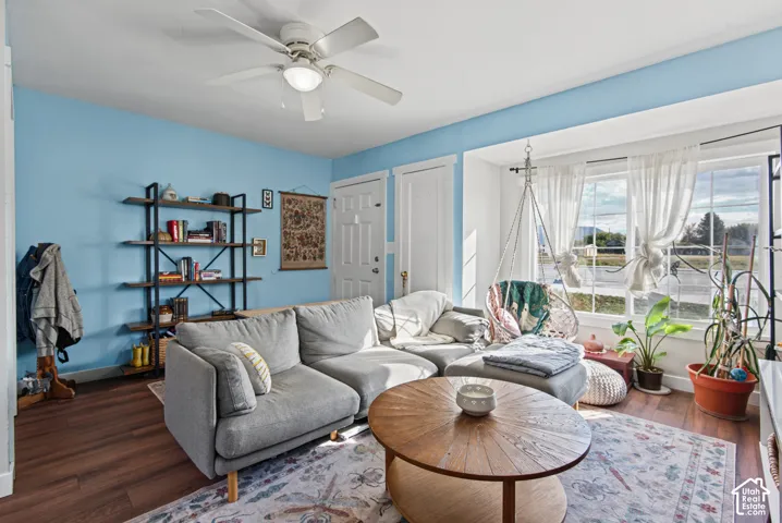 Wood-finish flooring, built-in shelving, white trim, and a ceiling fan with integrated lighting