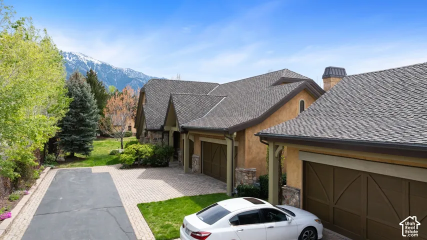 Stucco exterior with stone accents and a multi-gabled roofline