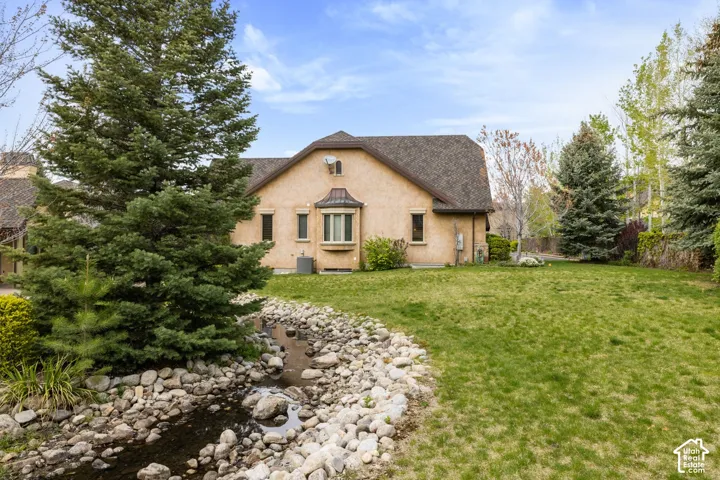 Expansive lawn with a rock-lined stream feature