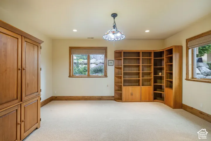 Built-in wood-finish cabinetry, built-in wood-finish shelving, recessed lighting, and a decorative ceiling fixture