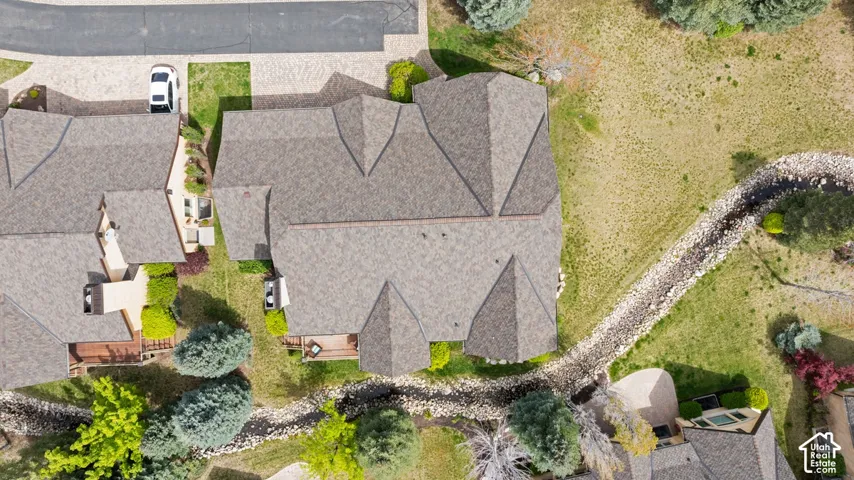 Property featuring a complex roofline, a paved driveway, and multiple rear decks
