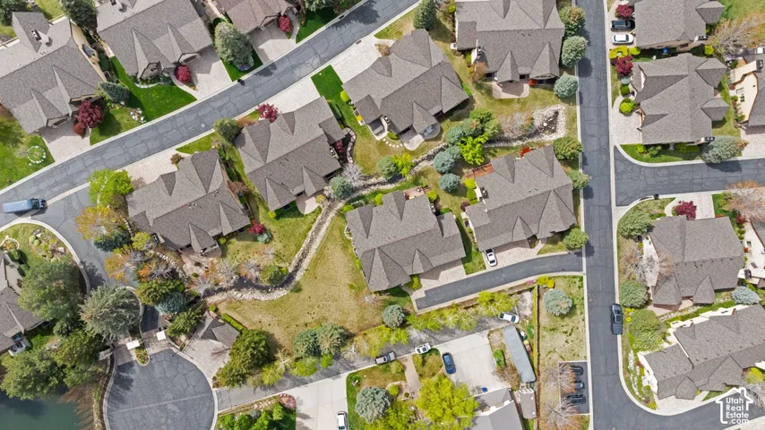 Residential neighborhood with mature trees, paved streets, and a centrally located water feature