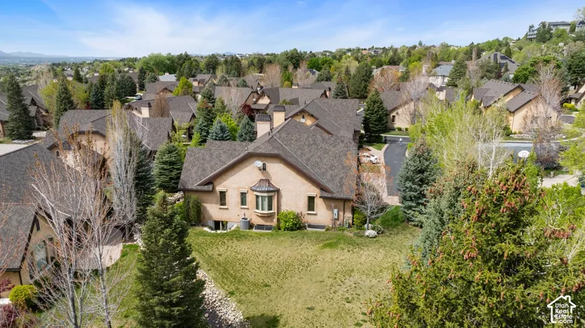 Stucco exterior with a bay window, gabled roofline, and established landscaping