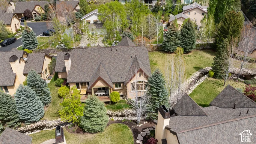 Residential property featuring a multi-gabled roof, multiple chimneys, and an exterior balcony