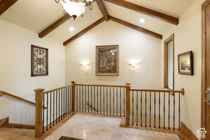 Vaulted ceiling with exposed wood beams and recessed lighting